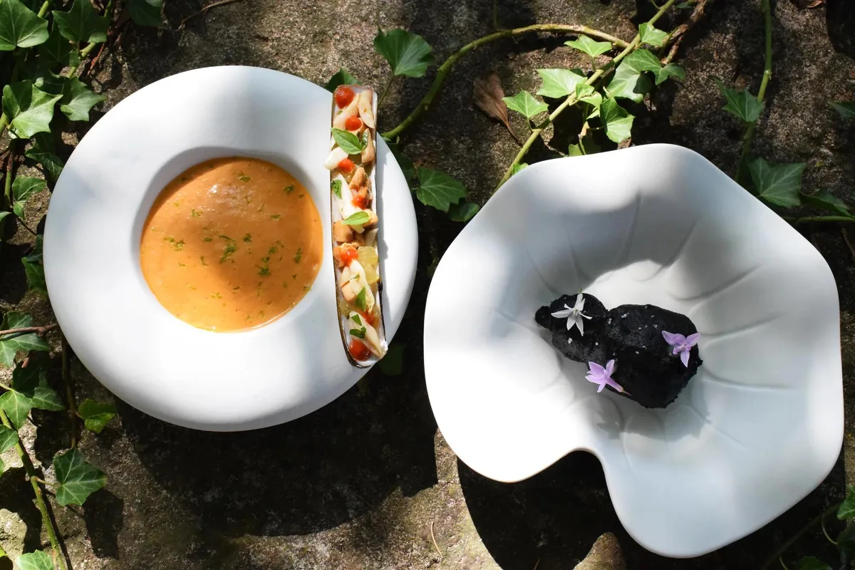 Deux assiettes du dîner gastronomique dressées sur un lit de lierre