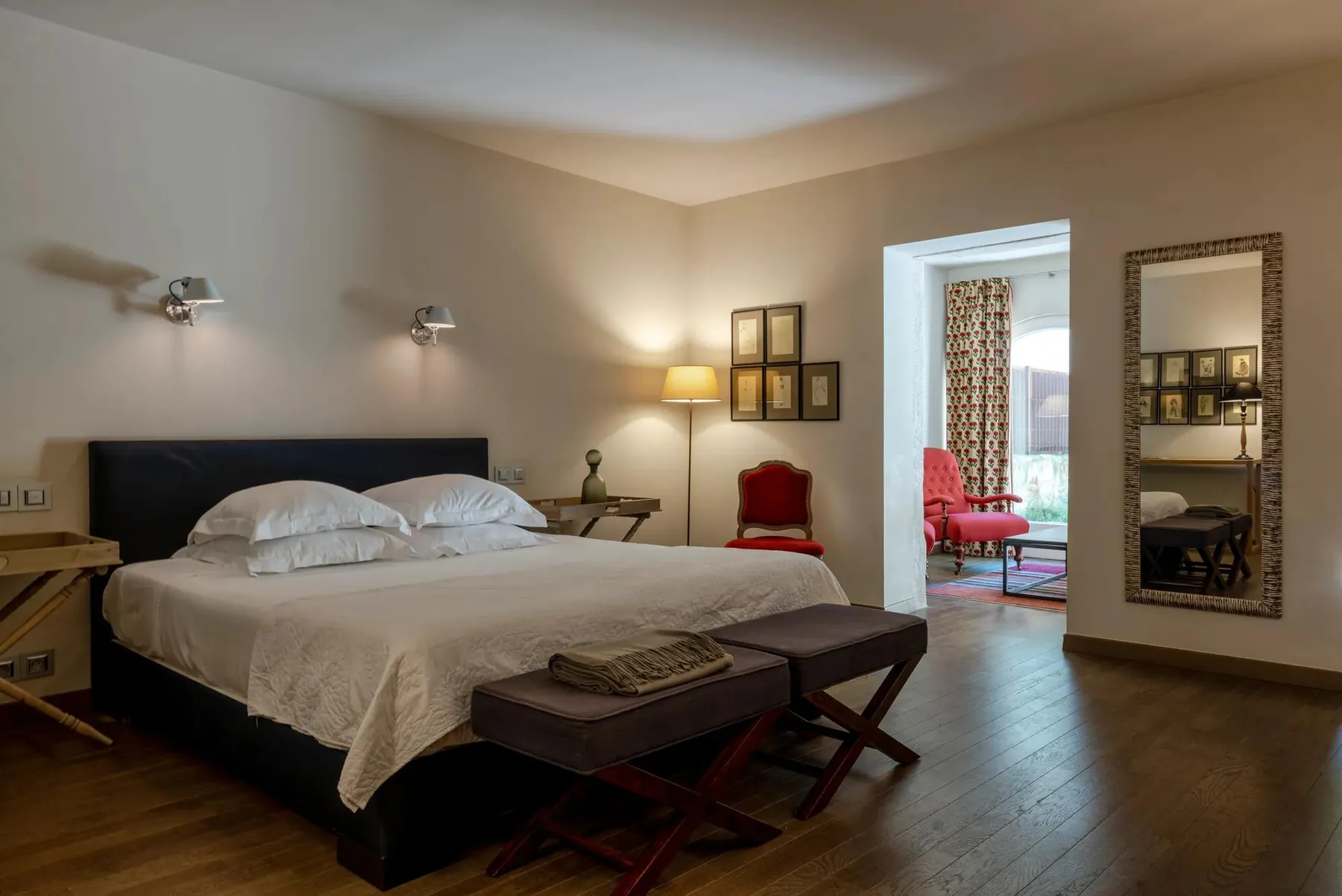 Chambre au lit blanc et fauteuils rouges
