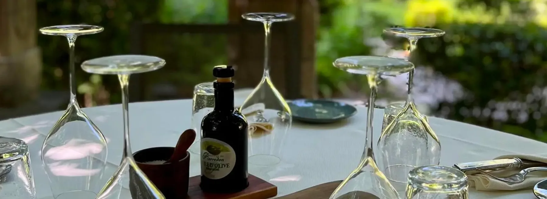 Verres et huile d'olive sur une table du jardin