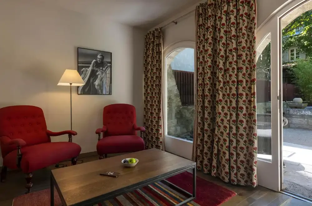 Suite Junior, fauteuils rouges et baie ouverte sur la verdure