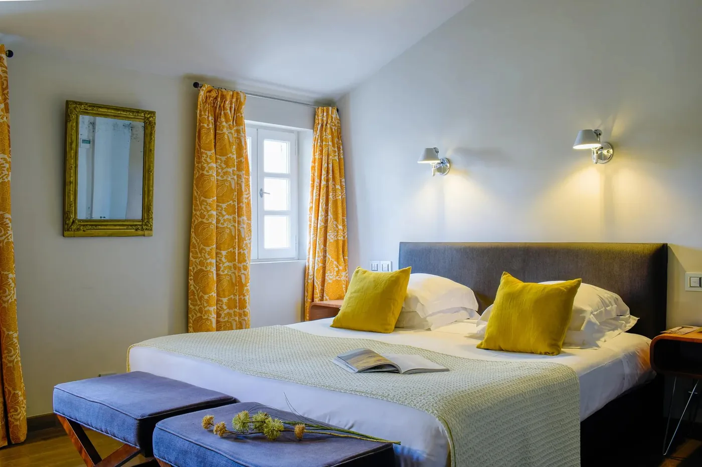 Chambre lumineuse aux coussins jaunes et rideaux imprimés
