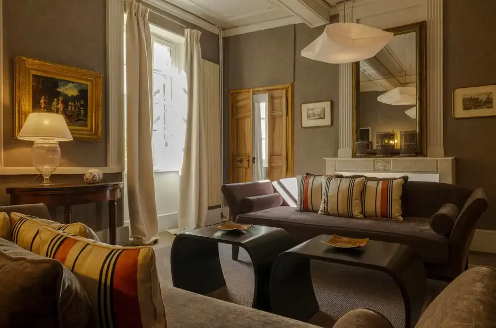 Suite, salon avec canapé rayé et lampes en suspension